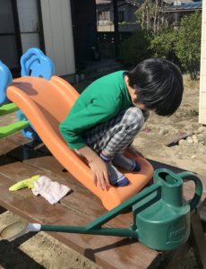 家の庭でおもちゃの滑り台で遊ぶ息子