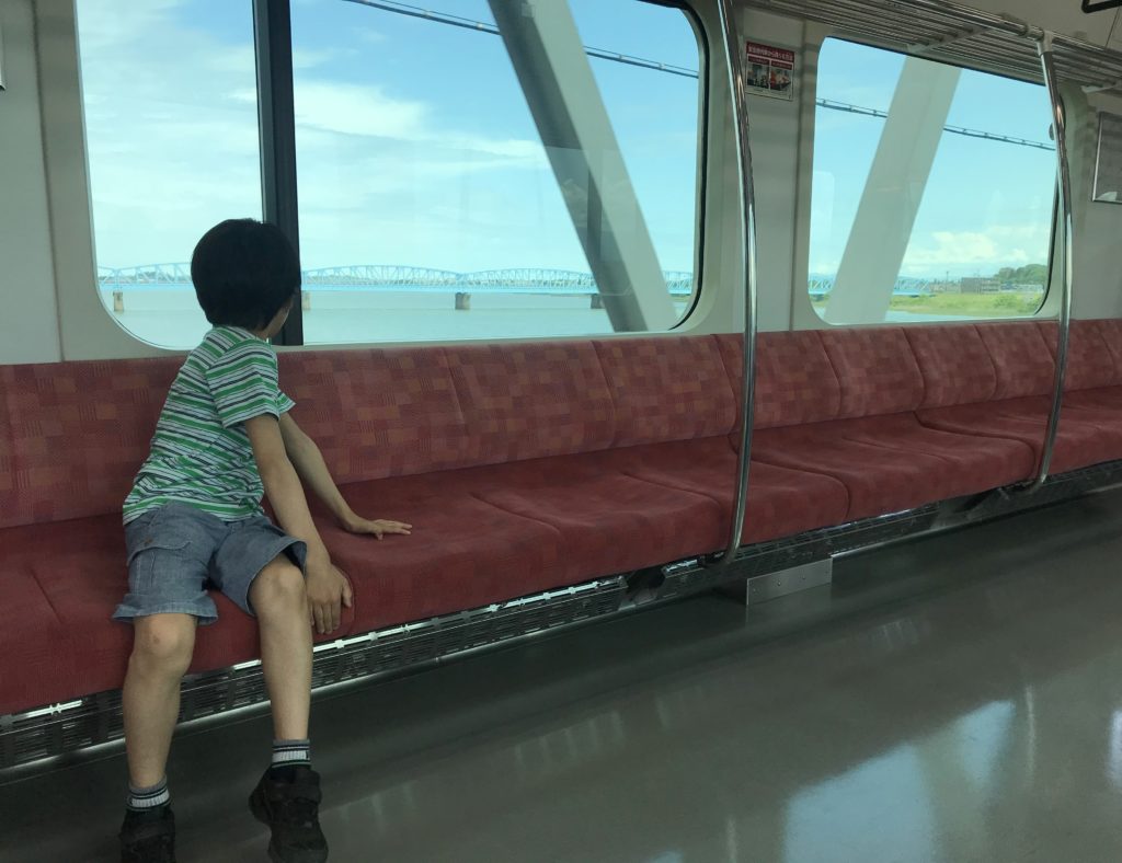 新潟駅に向かう電車に乗る息子。車窓から見えるのは阿賀野川