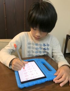 iPad miniを使って計算ドリルをする息子