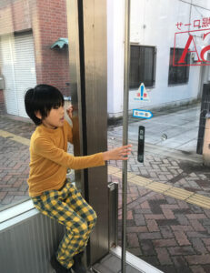 新潟市中央区「西堀ローサ」の地下出入口の自動ドアを開ける息子